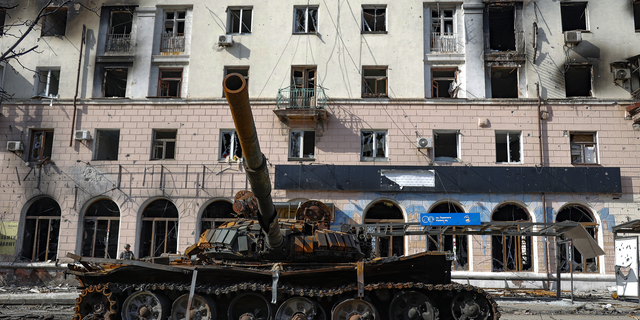 A destroyed tank and a damaged apartment building from heavy fighting in an area controlled by Russian-backed separatist forces in Mariupol, Ukraine, on April 26, 2022.
