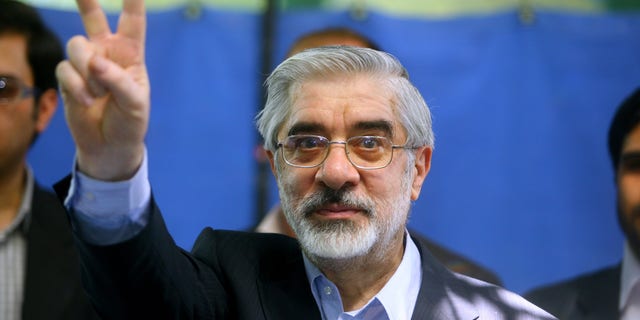 Presidential candidate Mir Hossein Mousavi flashes the V sign after casting his vote at a polling station on June 12, 2009, in Tehran, Iran. (Majid/Getty Images)