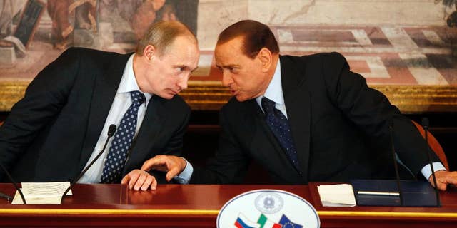 In this April 26, 2010, file photo, then Italian Premier Silvio Berlusconi, right, and Russian President Vladimir Putin talk during a press conference at Villa Gernetto, in Gerno, near Milan, Italy. The Kremlin is denying that President Vladimir Putin offered to make Silvio Berlusconi his economy minister, though he did extend "metaphorical support" to Italy's embattled ex-premier. (AP Photo/Luca Bruno, File)