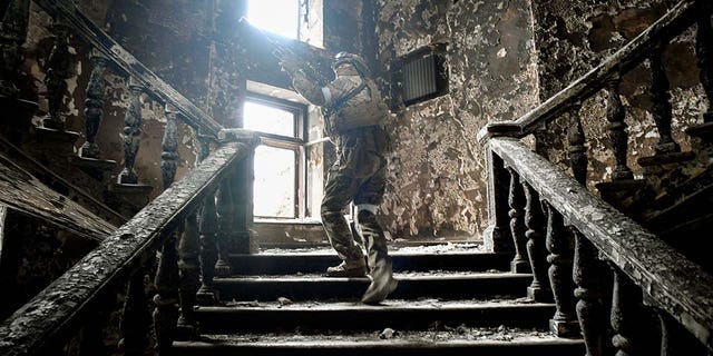 A Russian soldier climbs stairs at the Mariupol Drama Theatre, hit on March 16 by an airstrike, on April 12, 2022 in Mariupol, Ukraine. Russian troops intensify a campaign to take the strategic port city, part of an anticipated massive onslaught across eastern Ukraine, while Russia's President makes a defiant case for the war on Russia's neighbour.