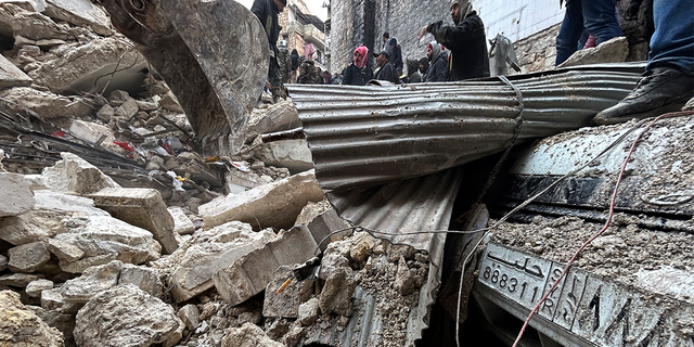 Syrian Civil Defense workers and security forces search through the wreckage of collapsed buildings, in Aleppo, Syria, Monday, Feb. 6, 2023.
