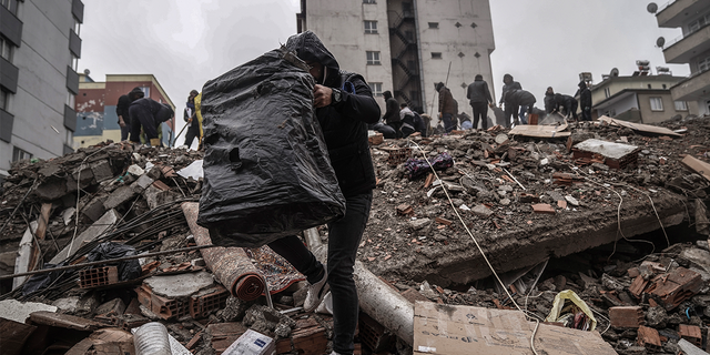 People and emergency teams search for people in the rubble in a destroyed building in Gaziantep, Turkey, Monday, Feb. 6, 2023.