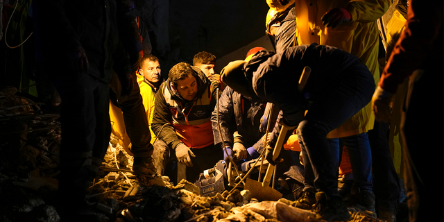 Emergency teams search in the rubble for people in a destroyed building in Adana, Turkey, Monday, Feb. 6, 2023.