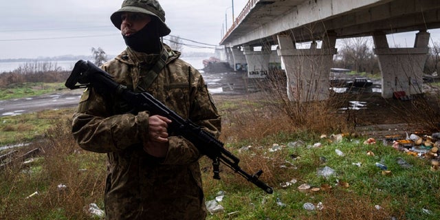 A Ukrainian serviceman patrols area near the Antonovsky Bridge which was destroyed by Russian forces after withdrawing from Kherson, Ukraine. The Biden administration announced Friday another $275 million in military aid to Ukraine. 