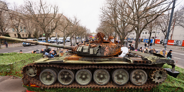 The remains of a destroyed Russian T-72 tank, secured from the Ukrainian village of Dmytrivka, outside Kyiv are on display near the the Brandenburg Gate during an event to mark the one-year anniversary of the Russian invasion of Ukraine, in Berlin, Germany, on Feb. 24.