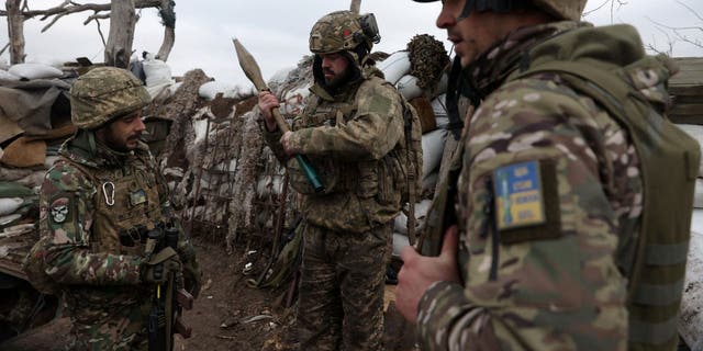 Ukrainian soldiers can be seen in a trench studying an RPG rocket on a frontline position in the Donetsk region on Jan. 23, 2023.