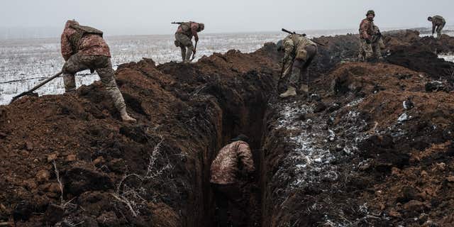 Ukrainian servicemen make a trench near Bakhmut on February 1, 2023, amid the Russian invasion of Ukraine. 