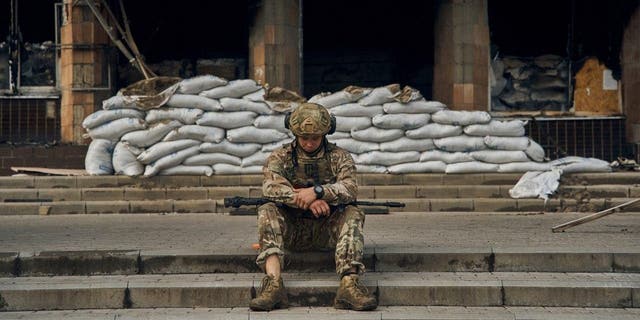 A Ukrainian soldier takes a rest on the steps of the City Hall in Izium, Kharkiv region, Ukraine, Tuesday, Sept. 13, 2022.