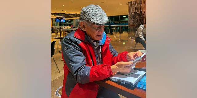 French serial killer Charles Sobhraj looks at his mobile phone in transit at Doha airport to France, on Dec. 23, 2022. Sobhraj, linked to at least two dozen murders in Asia in the 1970s and who inspired the Netflix series "The Serpent," was released in Nepal and transferred to France, where he is expected on Dec. 24, 2022 morning.