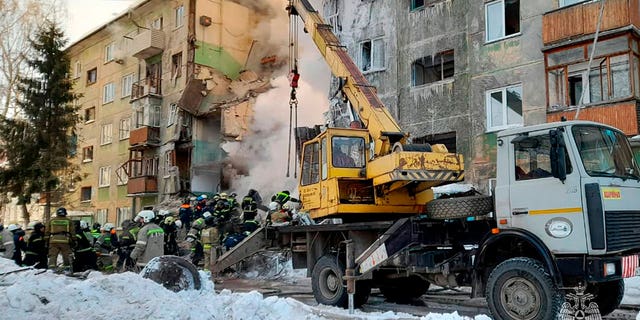 In this photo released by the Russian Emergency Ministry Press Service, Emergency service employees work at a site of a five-story residential building collapsed after the gas explosion in the Siberian city of Novosibirsk, Russia, on Feb. 9, 2023.