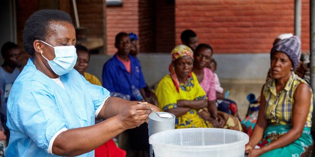 Violett Motta, a health surveillance assistant in Malawi, mixes chlorine with water to disinfect it at a health centre in response to the latest cholera outbreak in Blantyre, Malawi, on Nov. 16, 2022. 