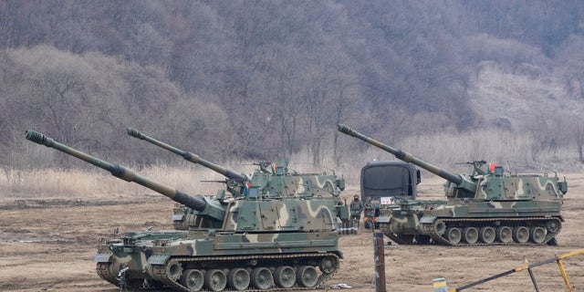 South Korean army soldiers work by K-9 self-propelled howitzers in Paju, South Korea, near the border with North Korea, Thursday, Feb. 16, 2023.