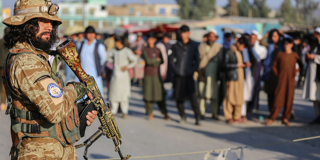 A Taliban security member stands guard along the Pakistan border in Nangarhar province, on Feb. 23. A new report said the Taliban are using fingerprint and gun records to track down those who helped the U.S.