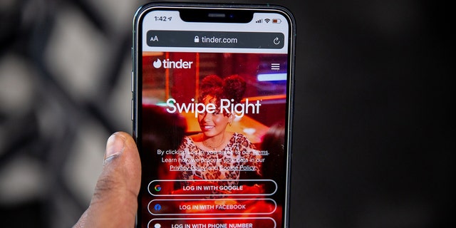 The homepage is displayed for the dating app Tinder on an iPhone.