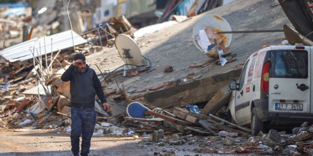 A man walks past debris from destroyed buildings in Antakya, southeastern Turkey, on Feb. 21, 2023. 