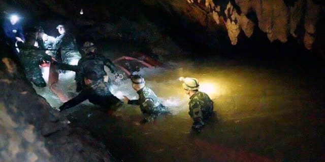 In this handout photo released by Tham Luang Rescue Operation Center, Thai rescue teams walk inside the cave complex during the rescue on July 2, 2018. 