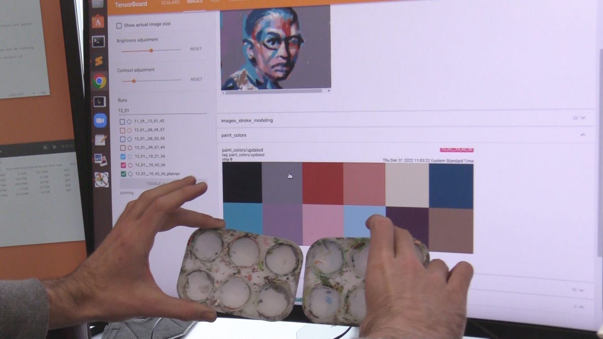 Two hands hold in front of a computer monitor with software that suggests the right paint colors