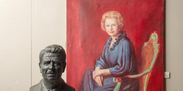 A large bronze plaster bust of President Ronald Reagan and an oil painting of Margaret Thatcher seated in a blue dress in a green armchair.