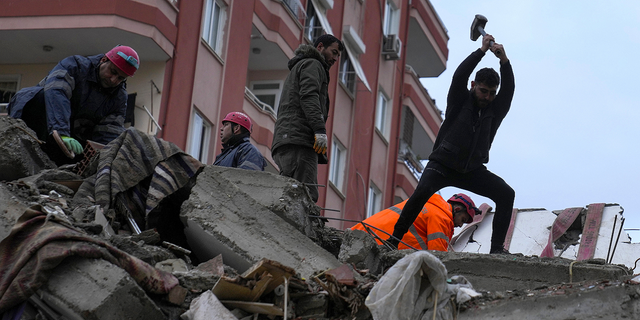Emergency team members and others search for people in a destroyed building in Adana, Turkey, on Monday, Feb. 6.