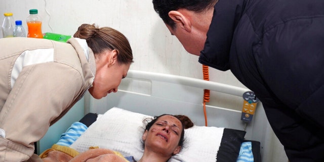 In this photo released by the official Syrian state news agency SANA, Syrian President Bashar Assad, left, and his wife Asma, visit a wounded survivor of a devastating earthquake, at a hospital in the coastal city of Latakia, Syria, Saturday, Feb. 11, 2023. 