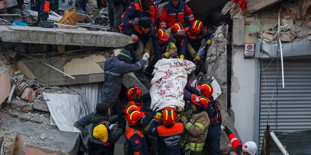 Turkish rescue workers carry Ergin Guzeloglan, 36, to an ambulance after pulled him out from a collapsed building five days after an earthquake in Hatay, southern Turkey, early Saturday, Feb. 11, 2023. 