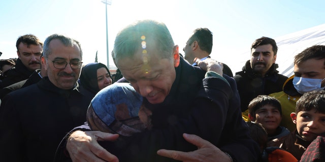 Turkey's President Recep Tayyip Erdogan and a survivor hug each other as he visits the city center destroyed by Monday earthquake in Kahramanmaras, southern Turkey, Wednesday, Feb. 8, 2023.