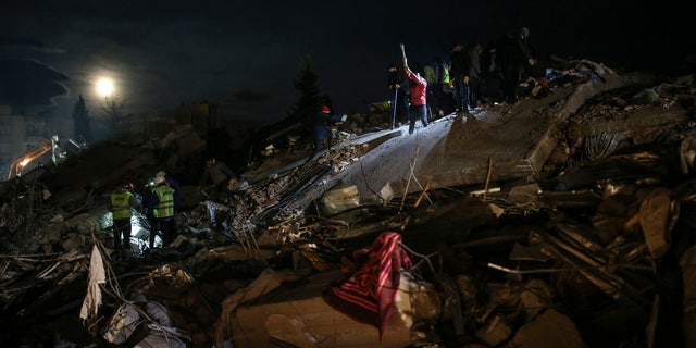 Rescue teams search for people at a destroyed building, in Adiyaman, southeastern Turkey, Wednesday, Feb. 8, 2023.