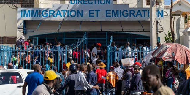 Haitians wait outside an immigration office to apply for a passport in Port-au-Prince on January 10, 2023. 