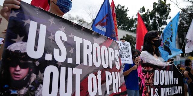 Demonstrators hold banners as they protest against the visit of U.S. Defense Secretary Lloyd Austin outside Camp Aguinaldo military headquarters in metro Manila, Philippines on Thursday, Feb. 2, 2023. 