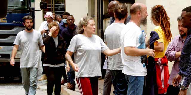 Seven of the Croatians charged with attempting to traffic children stand outside the magistrates court in Ndola, Zambia, on Jan. 10, 2023. All eight of the Croatians pleaded not guilty to the charge of child trafficking before a magistrate. 