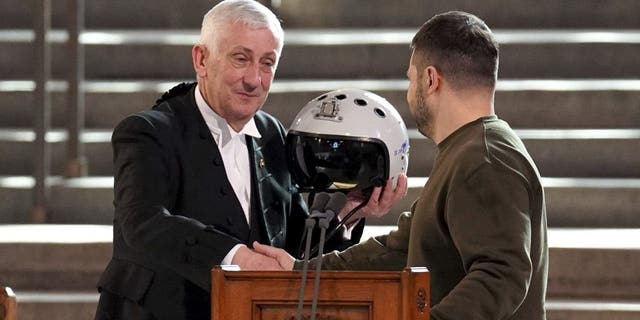 Sir Lindsay Hoyle holds the helmet inscribed with the words "We have freedom, give us wings to protect it," which was presented to him by President Volodymyr Zelenskyy in London on Wednesday Feb. 8, 2023.