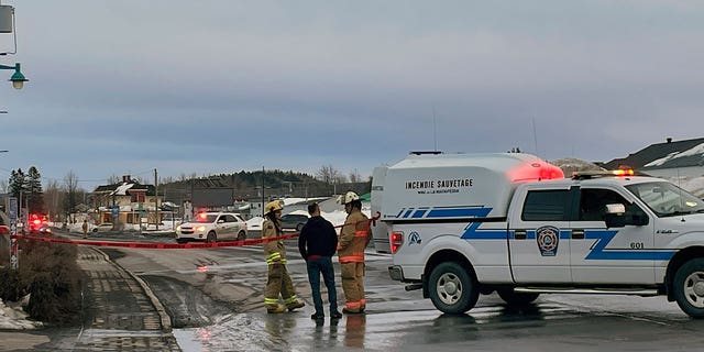 First responders work the scene where two men died after a pickup truck plowed into pedestrians who were walking beside a road in Amqui, Quebec, on March 13, 2023.