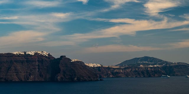 Towns sit above the cliffs of Santorini near the Aegean Sea, where an overloaded migrant boat capsized on March 1, 2023. Two of the migrants drowned while one remains missing.