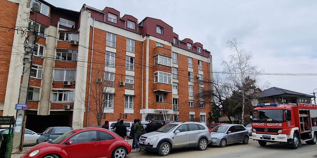 People look at a residential building after a response team extinguished an apartment fire in Novi Pazar, Serbia, on March 5, 2023. 