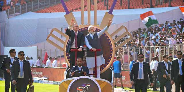 Indian Prime Minister Narendra Modi stands next to Australian Prime Minister Anthony Albanese as they arrive in the stadium to watch a cricket test match between India and Australia in Ahmedabad, India, on March 9, 2023. 