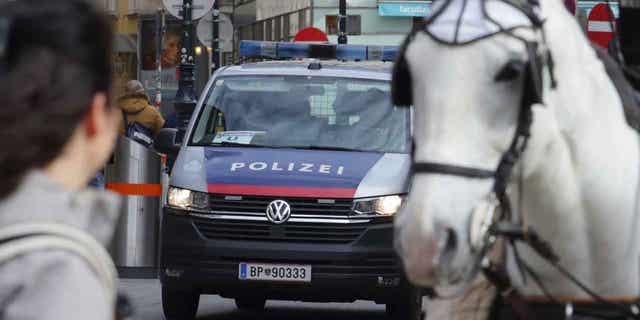 A police van drives past horses at a cathedral in Vienna, Austria, on Mar 15, 2023. Austrian police are warning of a possible "Islamist-motivated attack" targeting churches in Vienna.