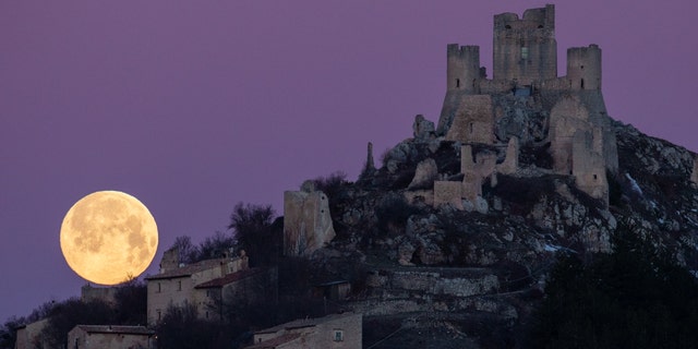 Full moon sets behind Rocca Calascio castle and village (LAquila), Italy, on March 7, 2023. March full moon is also known as the worm moon, because it coincides with the time of year when earthworms begin to emerge from the thawing soils. 
