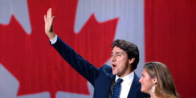 Justin Trudeau and his wife, Sophie Gregoire Trudeau, wave during an appearance at Liberal election headquarters in Montreal, Oct. 21, 2019. (Ryan Remiorz / The Canadian Press via AP)