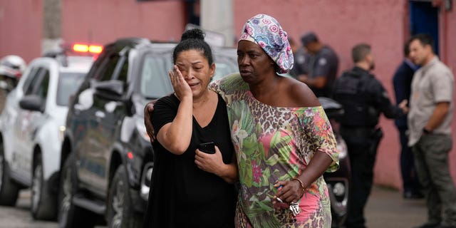 A Brazilian woman is consoled after learning her daughter was wounded in a stabbing attack.