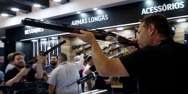 A visitor holds a rifle during the Shot Fair Brasil, an arms exhibition held at the Expoville Conventions and Exhibitions Centre in Joinville, Santa Catarina State, Brazil, on August 5, 2022.