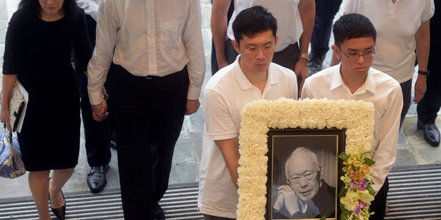 Family members of the late Prime Minister Lee Kuan Yew arrive with his portrait at the state funeral in Singapore on March 29, 2015. The brother of Singapore's current prime minister and son of late Lee Kuan Yew is accusing government authorities of persecuting his family.