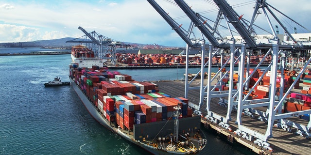 Drone shot of a massive container ship arriving in the Port of Long Beach, California.