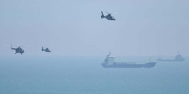 Chinese military helicopters fly past Pingtan Island, one of mainland China's closest points from Taiwan, in Fujian province on Aug. 4, 2022, ahead of military drills off Taiwan.