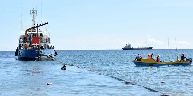 Workers prepare a tugboat to tow a ship at the Honiara port on Aug. 30, 2022.