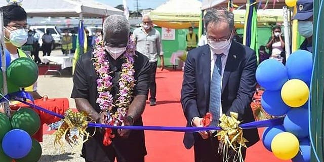 China's ambassador to the Solomon Islands, Li Ming, right, and Solomons Prime Minister Manasseh Sogavare cut a ribbon during the opening ceremony of a China-funded national stadium complex in Honiara on April 22, 2022.
