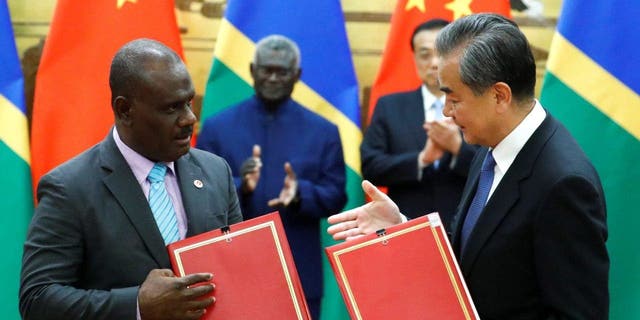 Chinese State Councilor and Foreign Minister Wang Yi and Solomon Islands Foreign Minister Jeremiah Manele attend a signing ceremony at the Great Hall of the People in Beijing on Oct. 9, 2019.