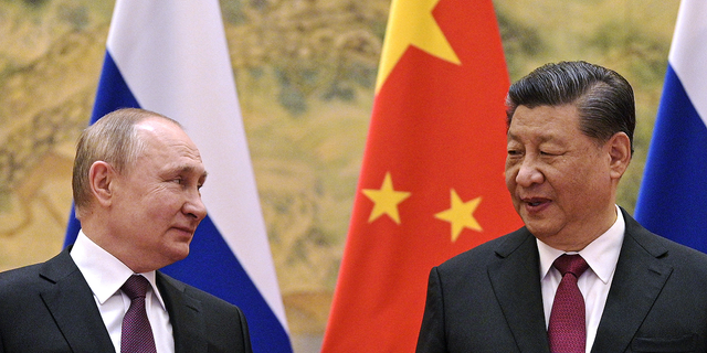 FILE: Chinese President Xi Jinping, right, and Russian President Vladimir Putin talk to each other during their meeting in Beijing, China on Feb. 4, 2022.
