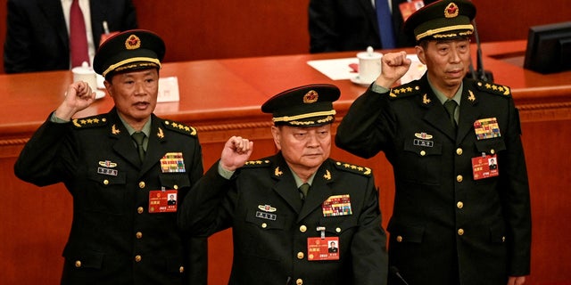 Zhang Youxia (C), newly-elected Vice Chairman of the Central Military Commission of the People's Republic of China, swears an oath with Central Military Commission members He Weidong and Li Shangfu after they were elected during the fourth plenary session of the National People's Congress (NPC) at the Great Hall of the People in Beijing on March 11, 2023. 