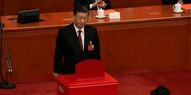 Chinese President Xi Jinping looks up after casting his vote to select state leaders during a session of China's National People's Congress (NPC) at the Great Hall of the People in Beijing, Friday, March 10, 2023. 