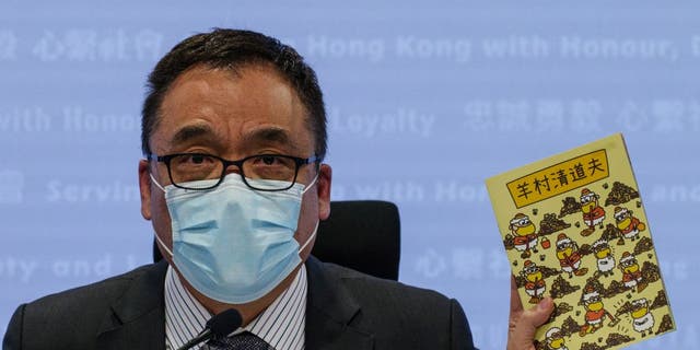 Hong Kong's senior superintendent Steve Li, from the city's new national security police unit, holds up a children's book which allegedly tries to explain about the city's democracy movement, at a police press conference in Hong Kong on July 22, 2021, after five members of a pro-democracy Hong Kong union were arrested for sedition for publishing the titles. 